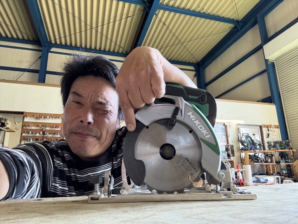 丸ノコの安全ガイドを指さす甲斐田社長